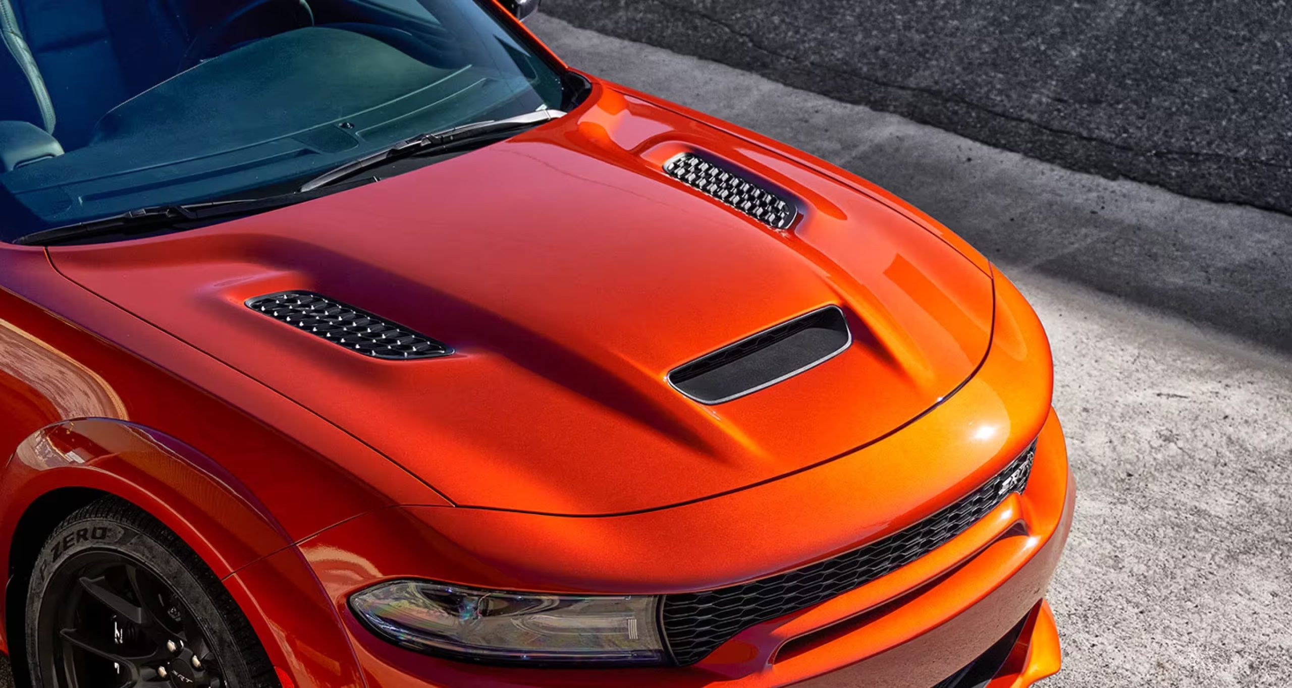 The hood of an orange 2023 Dodge Charger SRT Hellcat Widebody