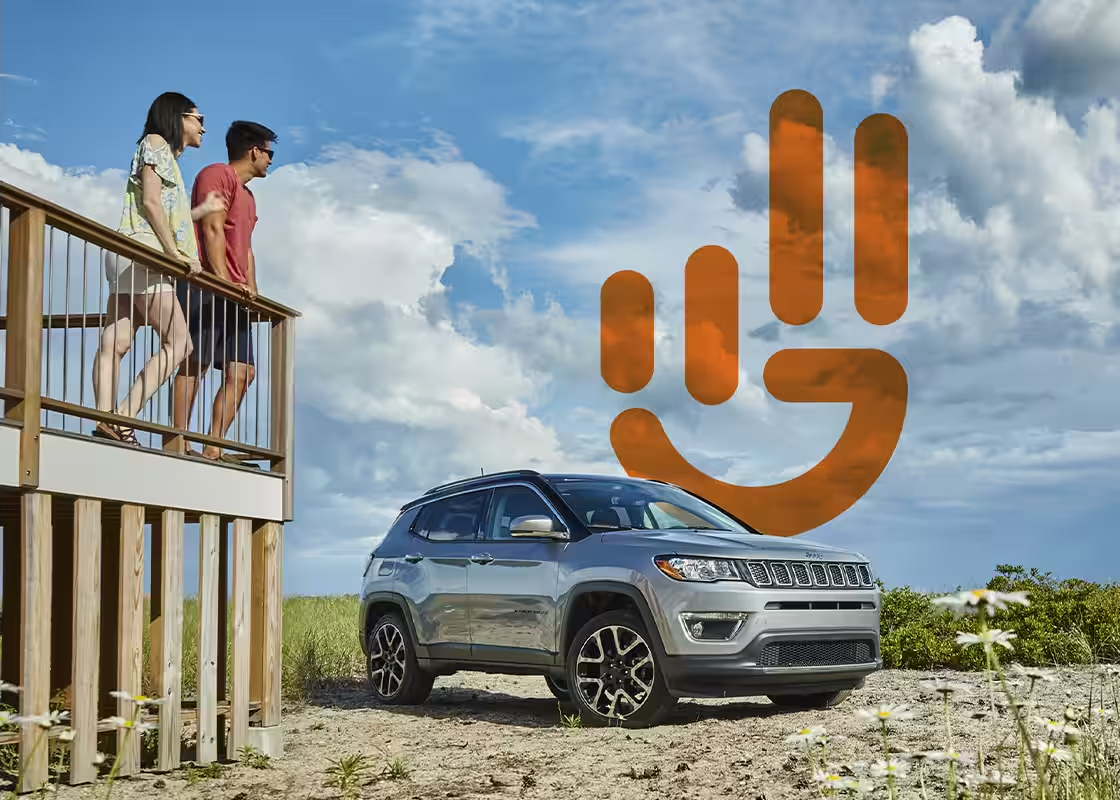 Jeep Wave program hero image. Two people on a deck overlooking a Jeep in a desert field