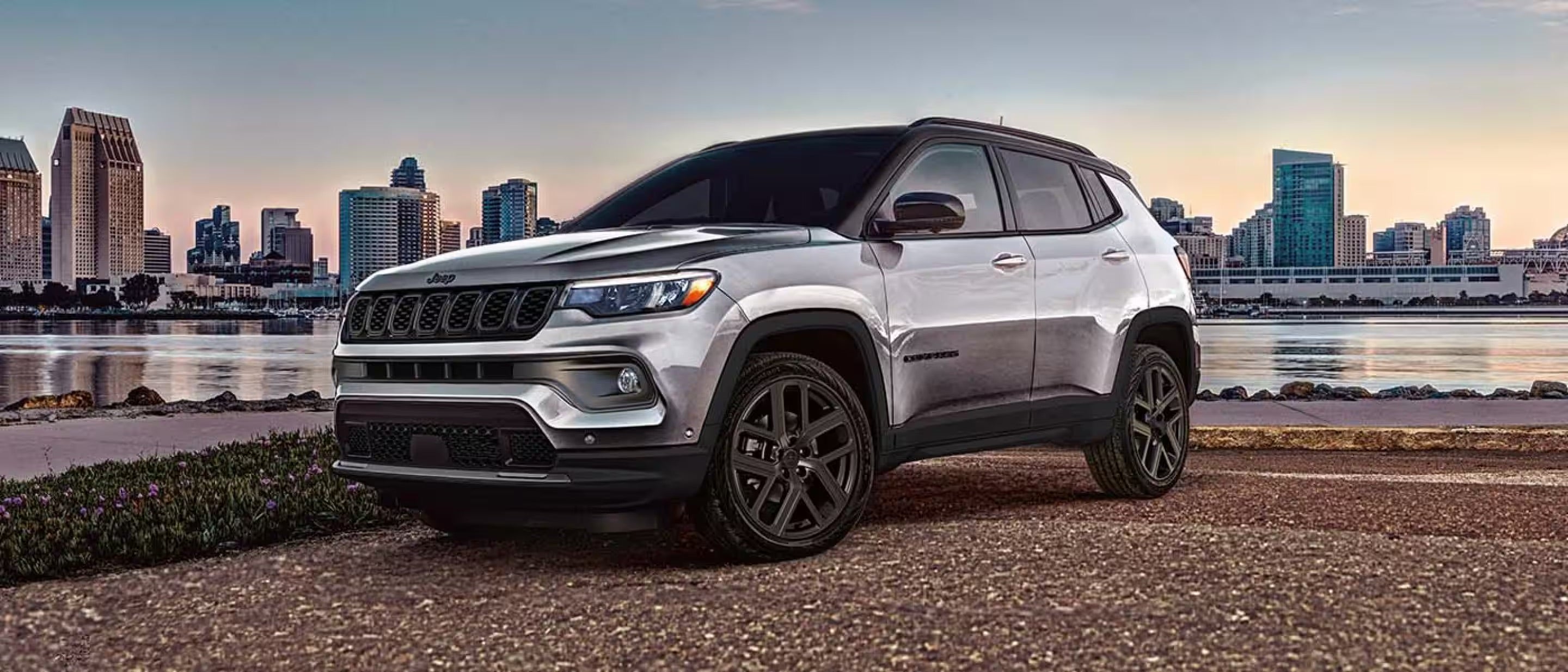 The new 2026 Jeep Compass parked in front of a city skyline in Baraboo, WI